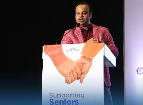 Dr. Tanmoy Karmakar speaking at the podium at the Supporting Seniors, Transforming Lives event.